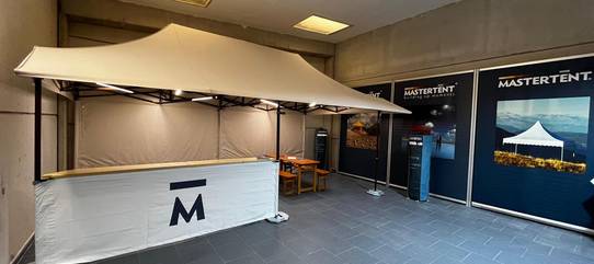 Showroom Zingerle Group: Faltzelt mit Mastertent Logo auf der halbhohen Seitenwand und Vordächer.